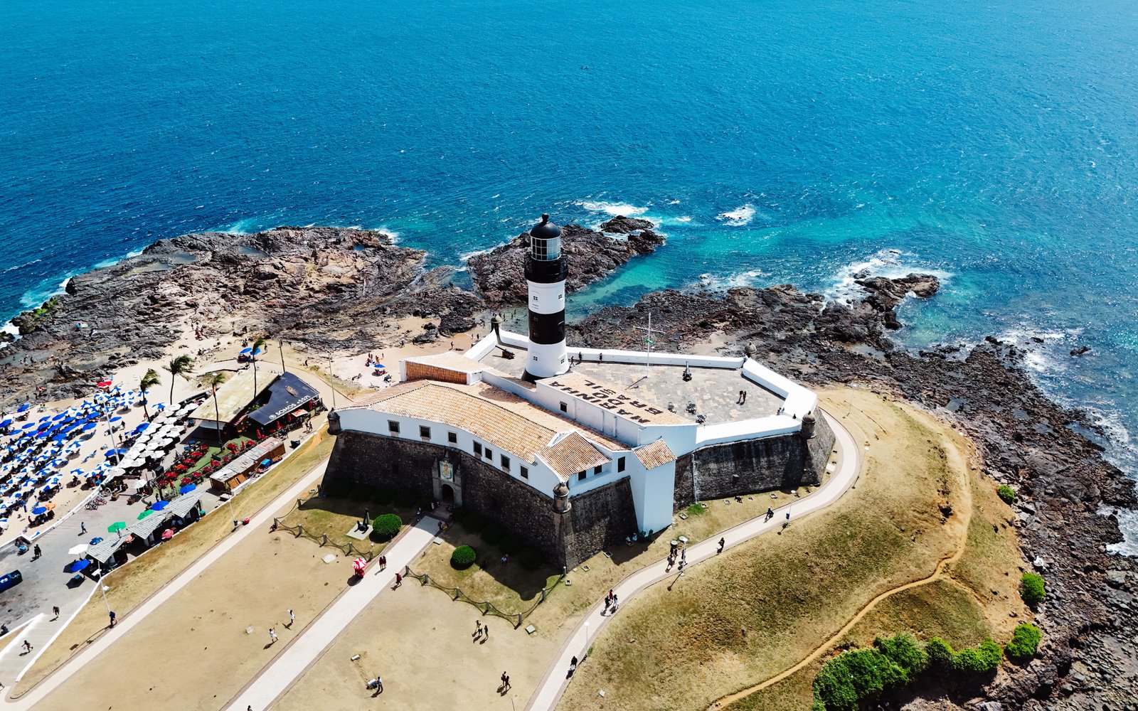 Vista aérea do Farol da Barra, cercado pelo azul do mar de Salvador